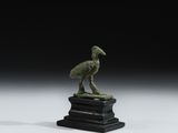 une image représentant une statue en bronze d'un oiseau posée sur un socle