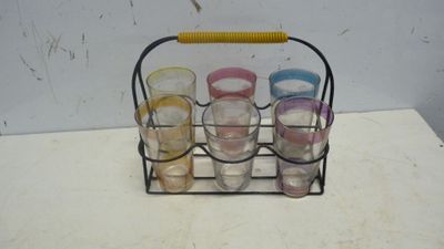 six verres dans un support en métal posé sur une table