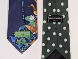 two ties with different designs on them on a table