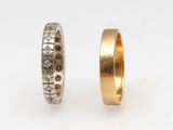 two gold wedding bands with diamonds on them