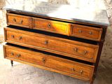 a wooden dresser with a marble top on a brick floor
