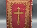 an old book with a cross on top of it