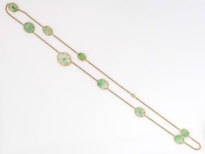 un gros plan d'un bracelet en or orné de pierres vertes