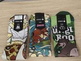 trois paires de chaussettes aux motifs différents posées sur une table
