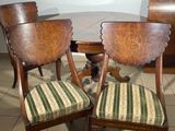 two wooden chairs sitting next to each other on a tile floor