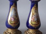 pair of blue and gold vases with a painting on them