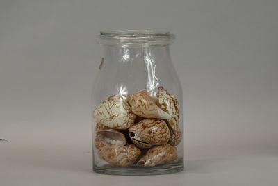a glass jar with shells in it on a table