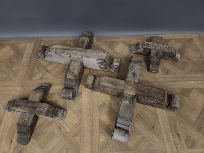 several pieces of wood sit on a wooden floor next to a wall