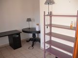 a room with a desk and a shelf in it