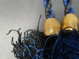 two balls of yarn and a gold bell on a table