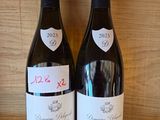 two bottles of wine sitting on a wooden shelf