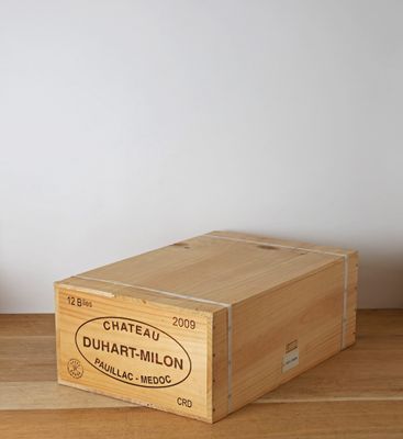 a wooden box sitting on a wooden table next to a plant