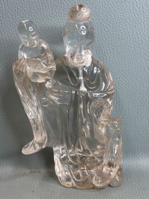 a glass figurine of a man sitting on a chair