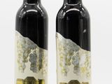 two bottles of olive oil sitting next to each other on a white surface