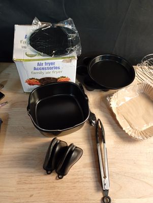 several pans and utensils on a table with a box of baking utensils