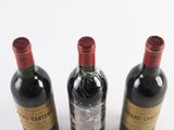 three bottles of wine sitting next to each other on a white surface