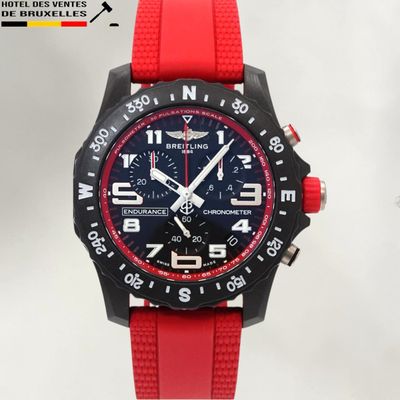 a close up of a wrist watch with a red strap