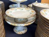 many plates and bowls stacked on a table with a blue background