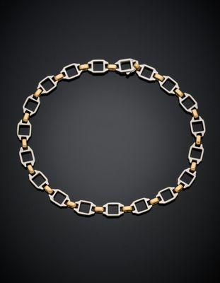 un collier à maillons dorés et argentés sur fond noir