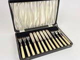 a black case with silverware in it on a white surface