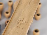someone is holding a wooden object in front of a group of other wooden objects