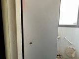 un réfrigérateur qui se trouve dans un coin de la salle de bains
