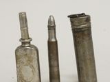 two old silver bottles and a bullet on a white surface