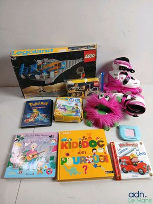 des jouets et des livres sont disposés par terre à côté d'une peluche
