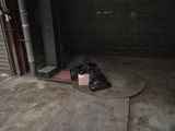 a bag of garbage sitting on the floor in a garage