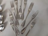 a lot of silver forks and spoons on a table