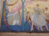 a painting on the wall of a building that has a painting of a woman and a deer