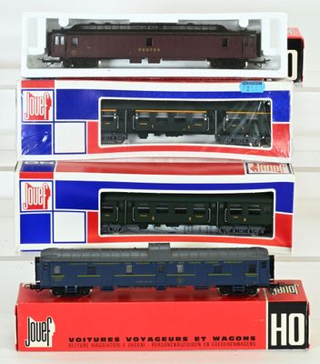 trois trains miniatures sont empilés les uns sur les autres sur une table