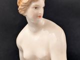 an image of a statue of a woman sitting on top of a table