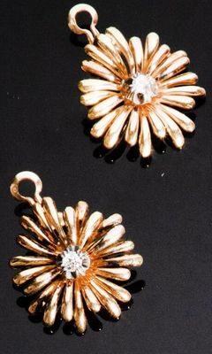 trois bijoux en or posés sur un fond noir
