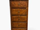 une vieille commode en bois surmontée de tiroirs