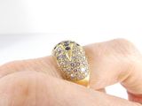a person holding a gold and diamond ring in their hand