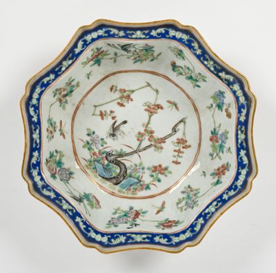 une assiette bleue et blanche ornée d'un oiseau et de fleurs