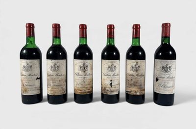 quatre bouteilles de vin sont alignées sur une surface blanche