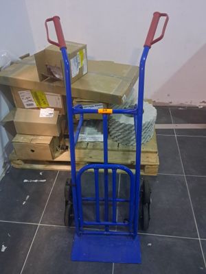 a blue hand truck with boxes on it in a room