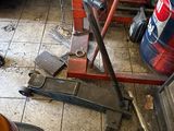 a car that is parked in a garage with tools on the floor