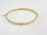 un gros plan d'un bracelet en or orné d'un petit diamant