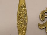 a gold spoon and a spoon with a flower design on it