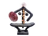 statue of a man holding a ball and standing on a bench