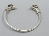 a close up of a silver bracelet with two claws on it