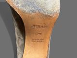 the bottom of a pair of shoes with a heel on a gray surface