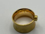 a close up of a gold ring on a white surface