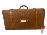 une valise marron posée sur une surface blanche