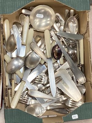 une boîte remplie de cuillères en argent et des cuillères posées par terre