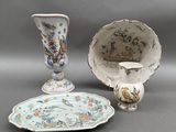 three different pieces of porcelain on display on a table