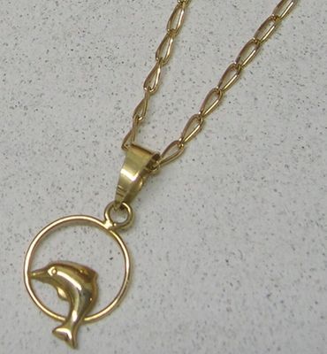 un collier en or orné d'un dauphin dans un cercle